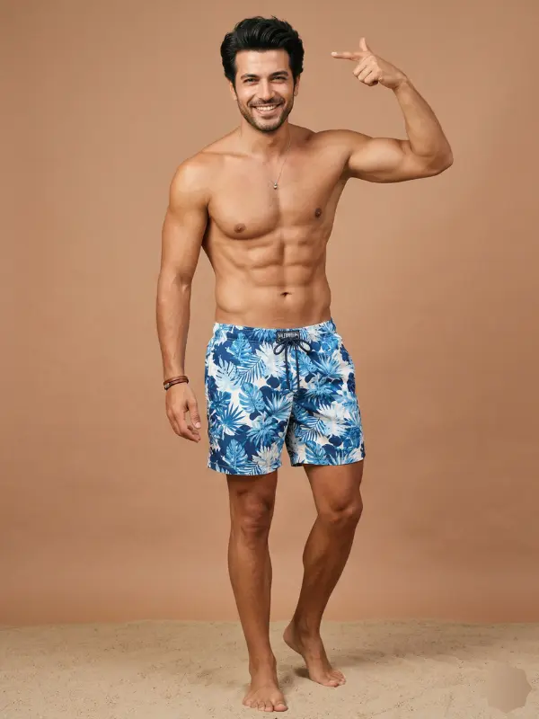 Symbolbild zu DHI-Haartransplantation, Gynäkomastie- und Sixpack-OP: Mann in Badeshorts, der auf sein Haar zeigt